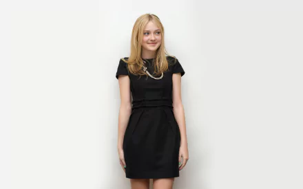 A smiling Dakota Fanning stands against a neutral backdrop, wearing a chic black dress. This image serves as a high-definition wallpaper featuring the American actress.