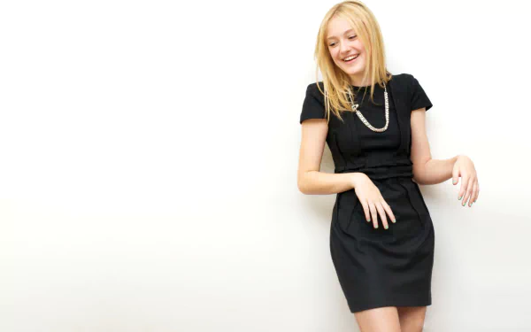 Dakota Fanning, an American actress, smiles playfully in a stylish black dress against a clean white background, making for a vibrant HD desktop wallpaper.