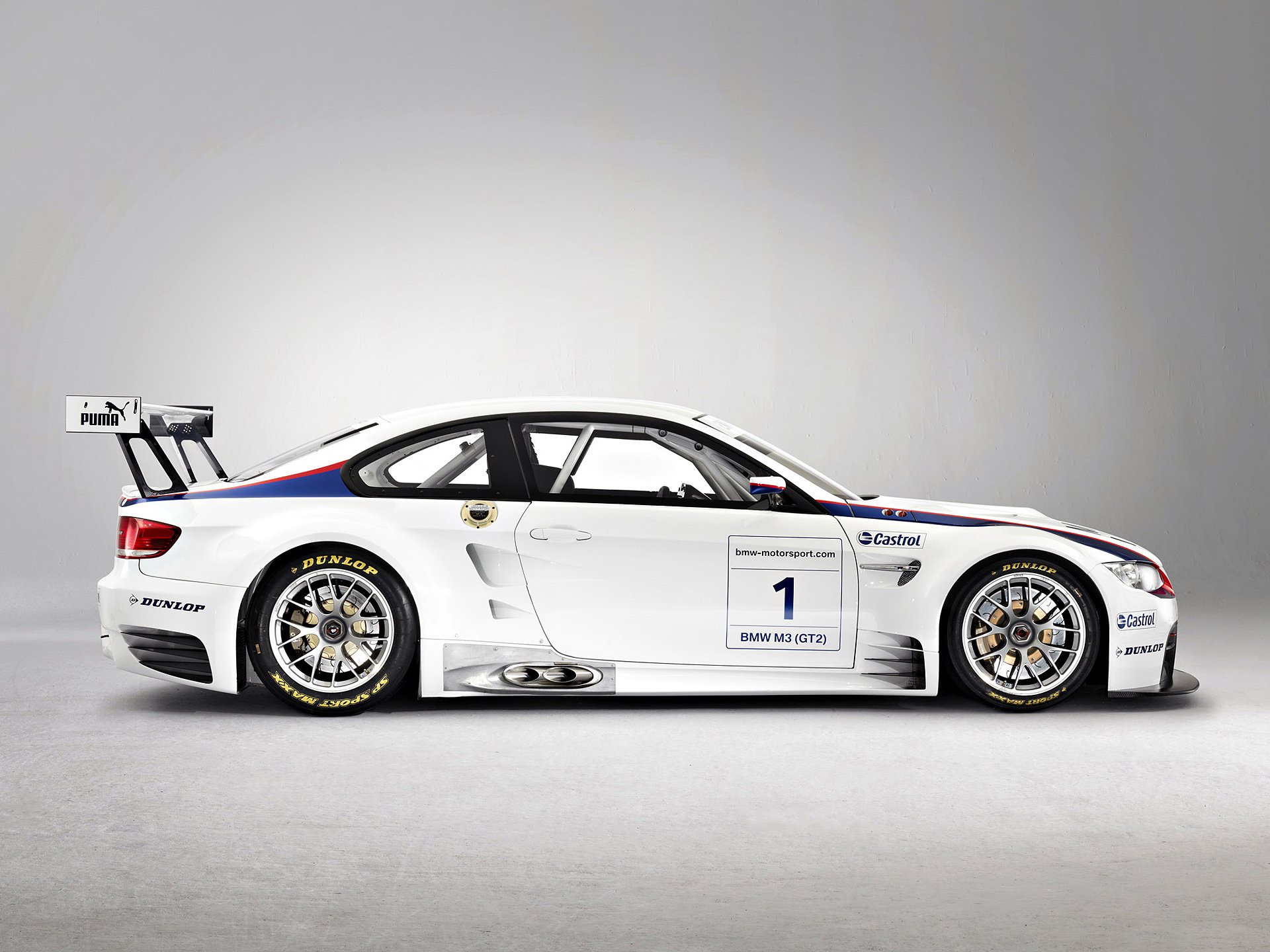 Side view of a white BMW M3 GT2 race car with sponsor decals and racing tires, shown as an HD PC desktop wallpaper and background.