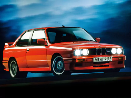 HD PC desktop wallpaper featuring a vibrant red BMW E30 M3 against a dramatic blue backdrop, showcasing the classic vehicle’s iconic design and headlights.