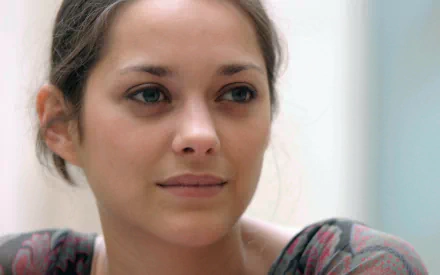 Close-up of French actress Marion Cotillard with a calm expression, featured in an HD PC desktop wallpaper and background.