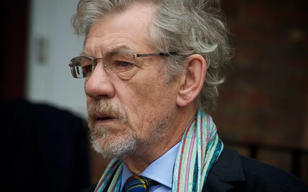HD desktop wallpaper featuring a close-up view of a distinguished older man with grey hair and a scarf, for background use.