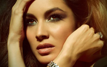 Close-up HD portrait of French actress Bérénice Marlohe with intense gaze, styled hair, and elegant accessories, featured as a PC desktop wallpaper.