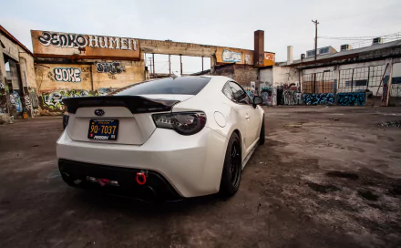 A Subaru BRZ parked in an urban setting with graffiti-covered walls. The image is a detailed 4K Ultra HD PC desktop wallpaper, capturing the vehicle's sleek design and surroundings.