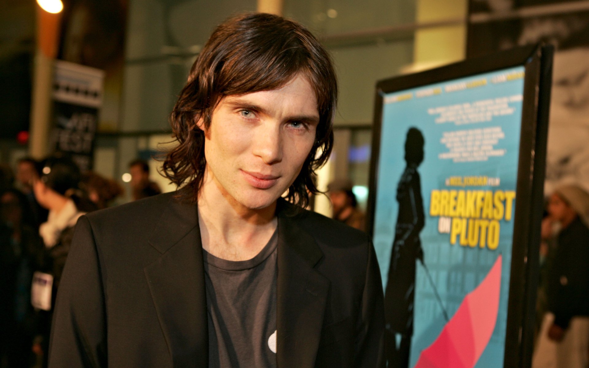 HD desktop wallpaper featuring Irish actor Cillian Murphy at a film event with a “Breakfast on Pluto” poster in the background.