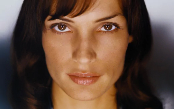 Close-up HD desktop wallpaper of Dutch actress Famke Janssen with soft lighting highlighting her facial features and warm expression.