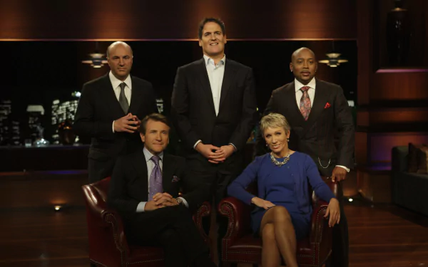 HD desktop wallpaper of five individuals from Shark Tank against a backdrop of city lights, posing confidently.