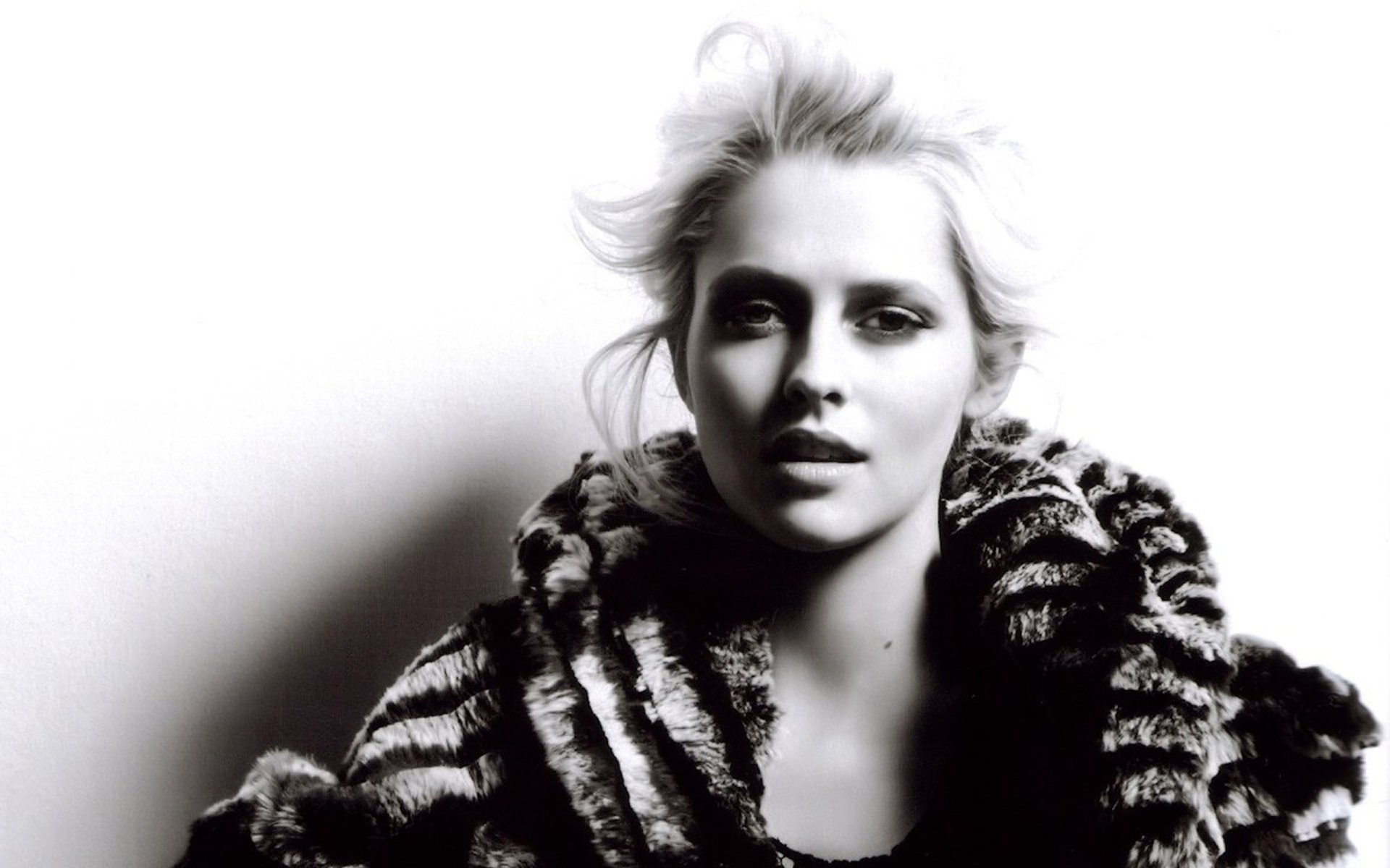 Black and white HD desktop wallpaper of Australian actress and celebrity Teresa Palmer wearing a textured fur coat against a light background.