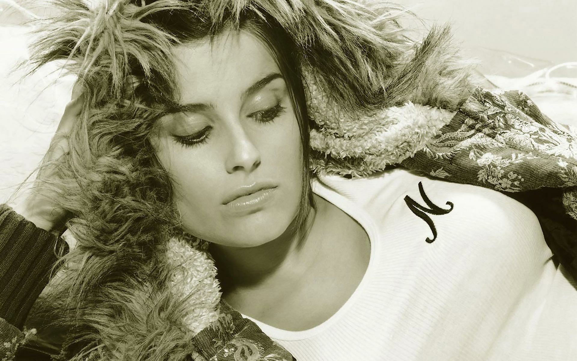 HD PC desktop wallpaper: sepia close-up of a woman in a fur-lined hood, eyes closed, wearing a white top with an N; music image tagged Nelly Furtado.