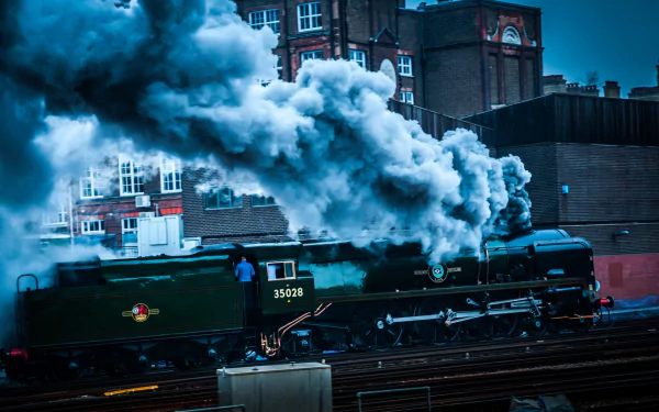 HD desktop wallpaper featuring a classic steam train emitting thick white smoke as it moves through an urban setting.
