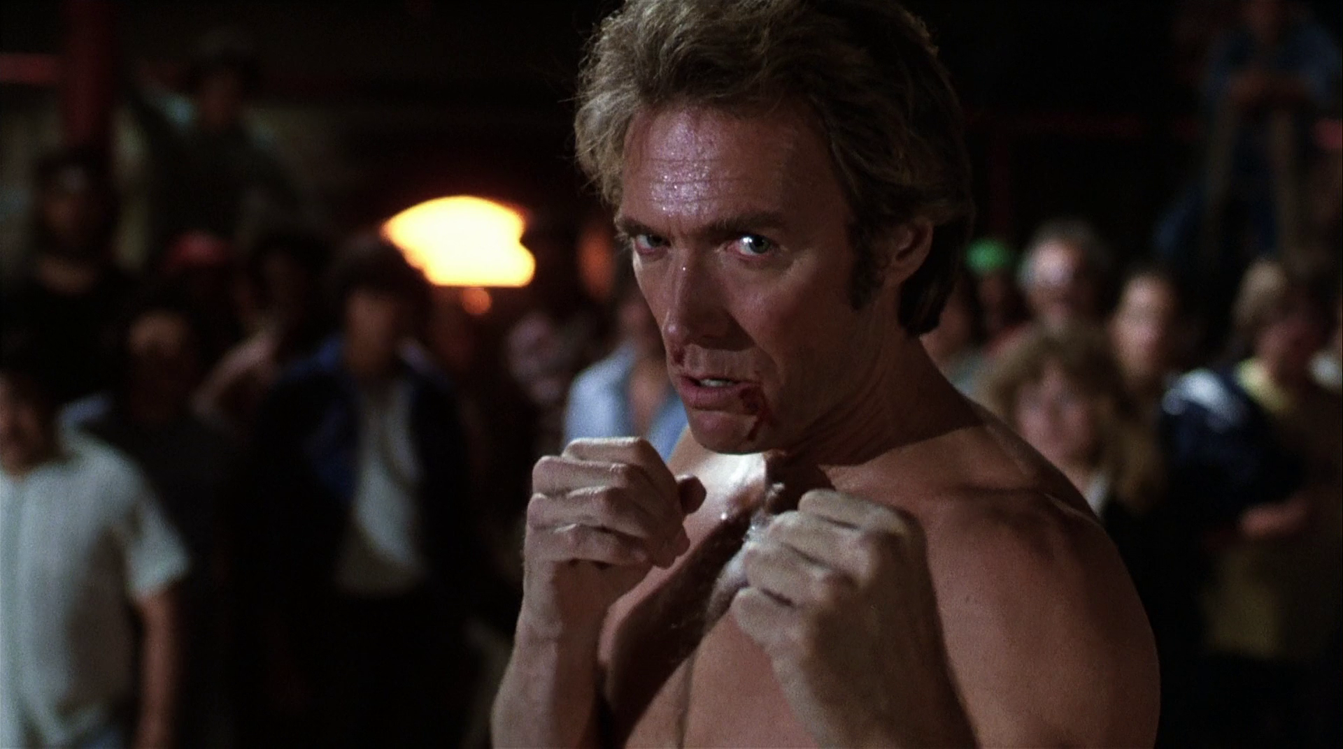 Shirtless man with fists raised in a crowded bar fight scene from the movie Every Which Way But Loose — HD PC desktop wallpaper and background.