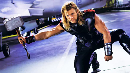 HD PC desktop wallpaper featuring Chris Hemsworth as Thor from the Avengers, wielding his iconic hammer in a dynamic action pose.