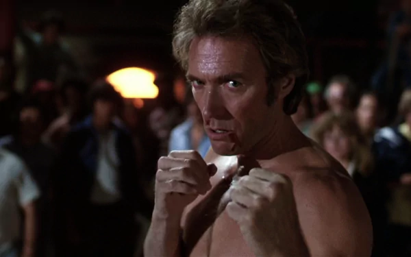 Shirtless man with fists raised in a crowded bar fight scene from the movie Every Which Way But Loose — HD PC desktop wallpaper and background.