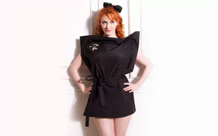 HD desktop wallpaper featuring American actress and celebrity Christina Hendricks posing confidently in a stylish black outfit against a white background.