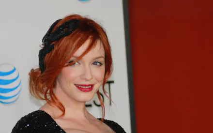 HD desktop wallpaper featuring American actress and celebrity Christina Hendricks with red hair and a black outfit against a red and white backdrop.