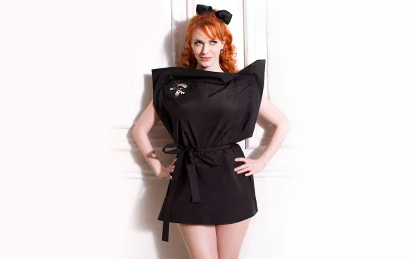 HD desktop wallpaper featuring American actress and celebrity Christina Hendricks posing confidently in a stylish black outfit against a white background.