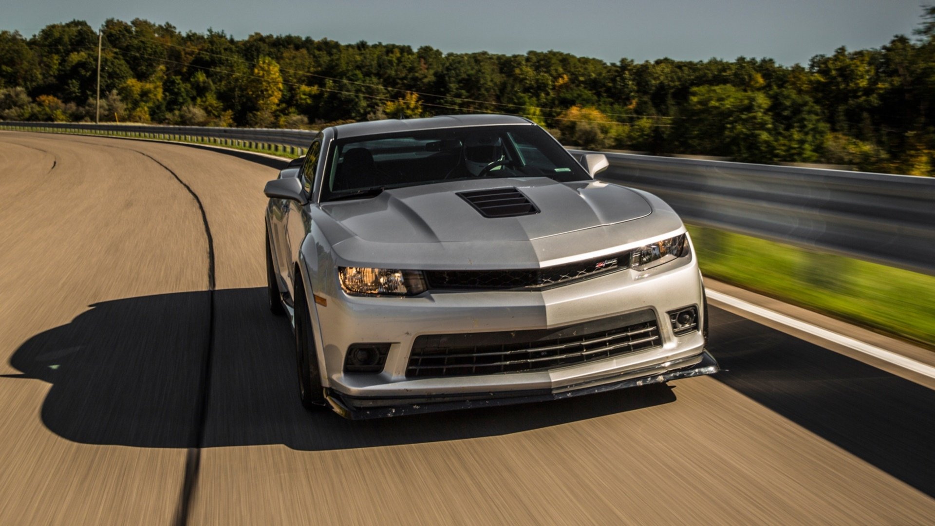 A sleek Chevrolet Camaro Z28 speeding down a curved road, captured in an HD PC desktop wallpaper and background.