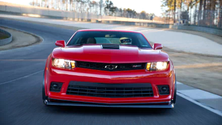 A striking red Chevrolet Camaro Z28 captured in motion on a racetrack, showcased as a high-definition PC desktop wallpaper.