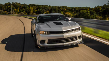 A sleek Chevrolet Camaro Z28 speeding down a curved road, captured in an HD PC desktop wallpaper and background.