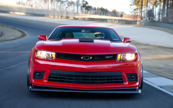 A striking red Chevrolet Camaro Z28 captured in motion on a racetrack, showcased as a high-definition PC desktop wallpaper.