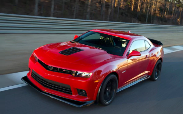 A red Chevrolet Camaro Z28 speeding on a racetrack, captured in a high-definition desktop wallpaper background.