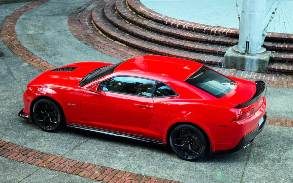 A vibrant red Chevrolet Camaro Z28 parked on a brick and concrete surface, showcased in an HD PC desktop wallpaper and background.