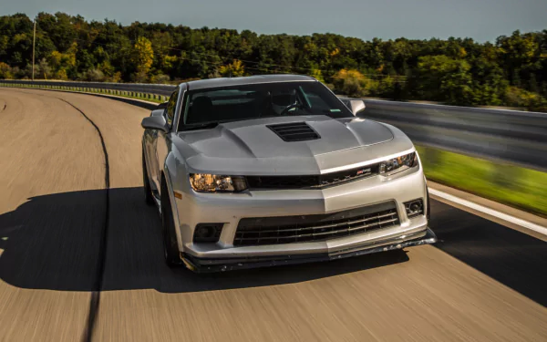 A sleek Chevrolet Camaro Z28 speeding down a curved road, captured in an HD PC desktop wallpaper and background.