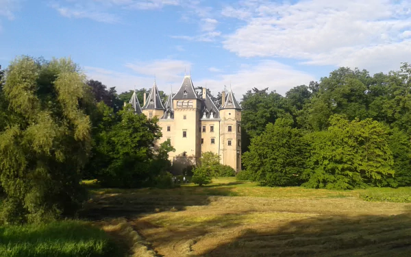 HD PC desktop wallpaper featuring the man-made Goluchów Castle surrounded by lush greenery under a partly cloudy sky.