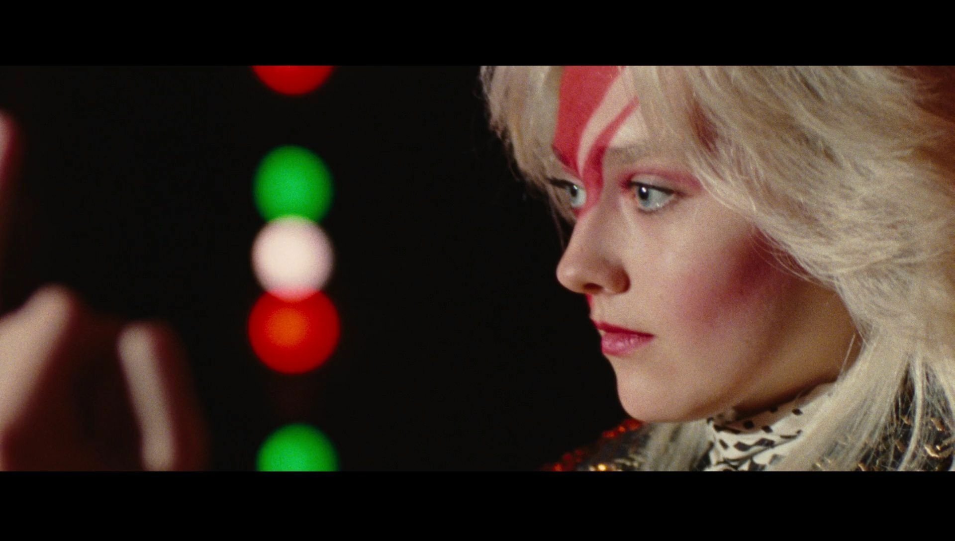 HD PC desktop wallpaper featuring Dakota Fanning as Joan Jett from the movie The Runaways, with distinctive lightning bolt face makeup and intense side profile.