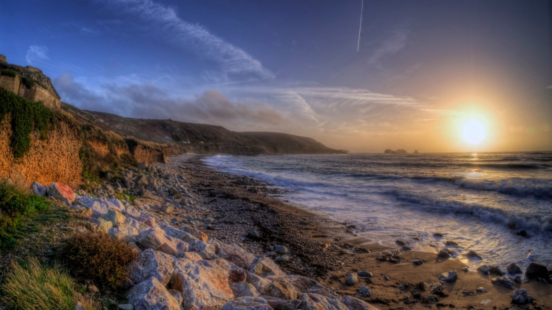 Sunset over the rocky coastline near the man-made Fort Clonque, captured in this HD PC desktop wallpaper and background.