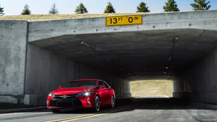 HD PC desktop wallpaper background showing a red 2015 Toyota Camry vehicle in a concrete underpass, sunlight ahead and a 13 ft clearance sign overhead.