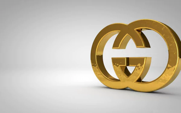 A golden Gucci logo set against a sleek gray background, designed as an HD desktop wallpaper, showcasing a modern and luxurious aesthetic.