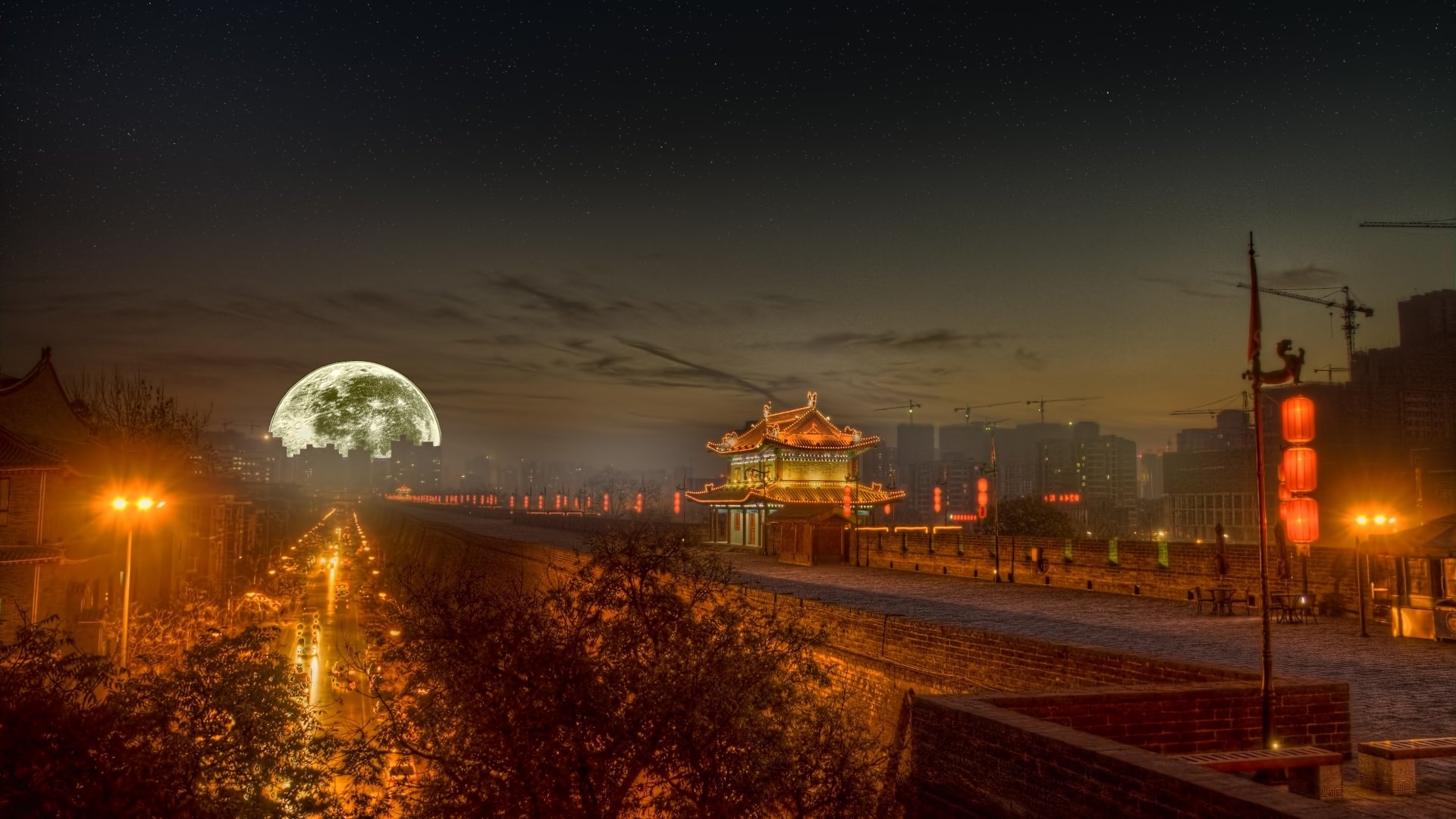 A stunning HD scenic wallpaper capturing a night view of a historic building illuminated by streetlights, with a large full moon casting a serene glow over the landscape.