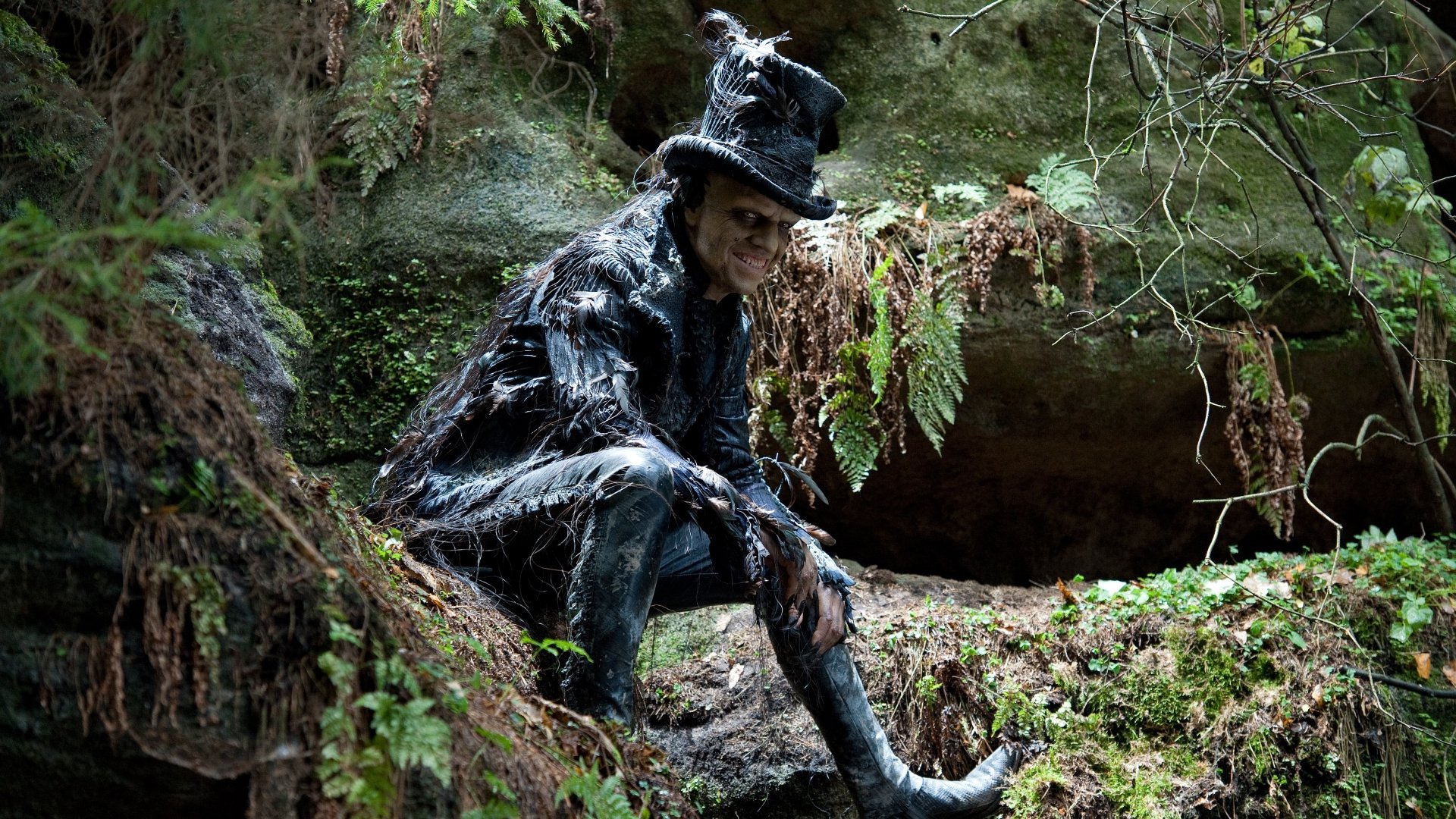 4K Ultra HD PC desktop wallpaper featuring a darkly dressed character from the movie Cloud Atlas, seated in a lush forest with moss and ferns surrounding them.