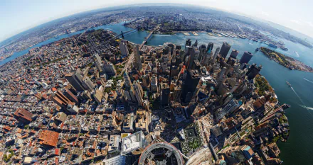 A high-definition aerial view of Manhattan, showcasing the dense urban landscape with One World Trade Center prominently rising among the man-made structures of New York.