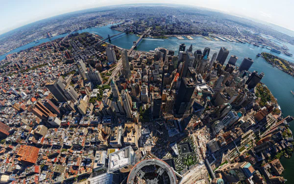 A high-definition aerial view of Manhattan, showcasing the dense urban landscape with One World Trade Center prominently rising among the man-made structures of New York.