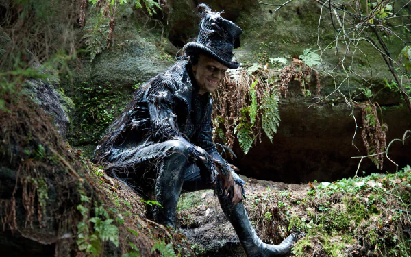 4K Ultra HD PC desktop wallpaper featuring a darkly dressed character from the movie Cloud Atlas, seated in a lush forest with moss and ferns surrounding them.