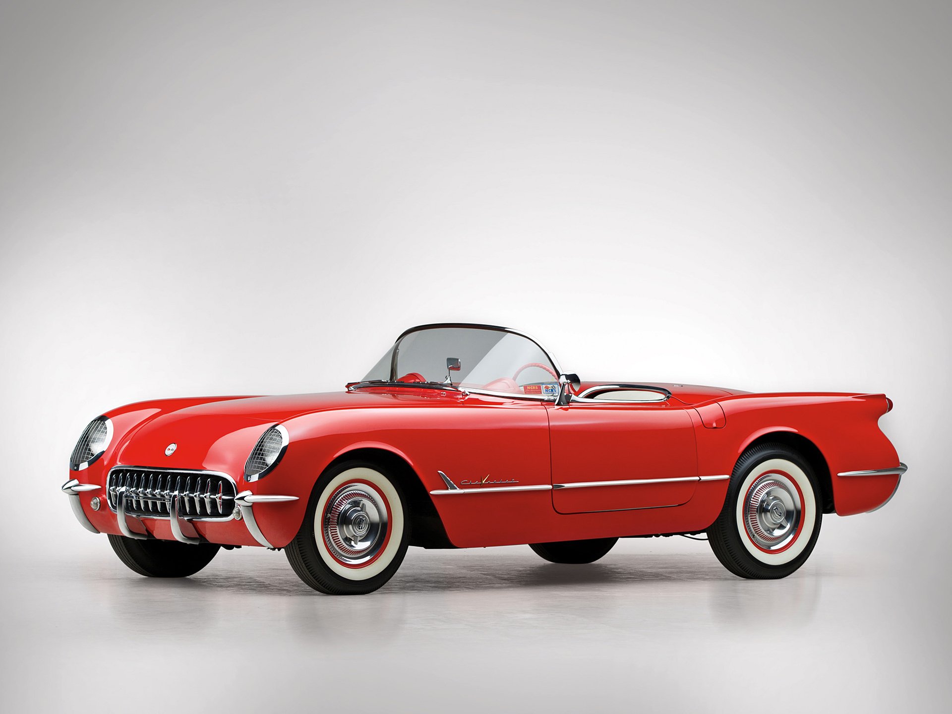 HD PC wallpaper featuring a classic red Chevrolet Corvette (C1) convertible, showcasing the iconic design of this vintage Chevrolet vehicle.