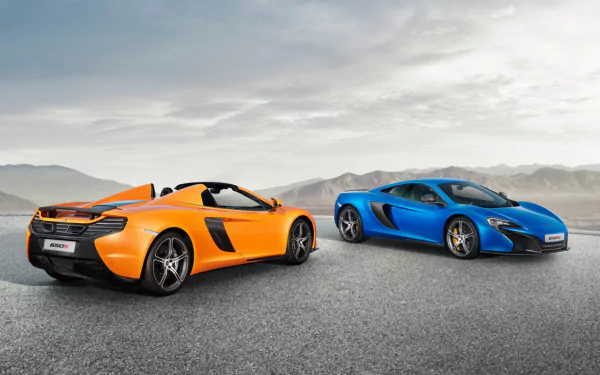 Two McLaren 650S supercars, one orange and one blue, parked on a wide open asphalt surface under a cloudy sky in this HD PC desktop wallpaper.