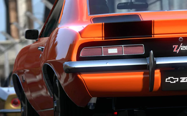 A vibrant orange Chevrolet Camaro Z28 captured from the rear, showcased as an HD PC desktop wallpaper featuring vivid detail and classic muscle car design.