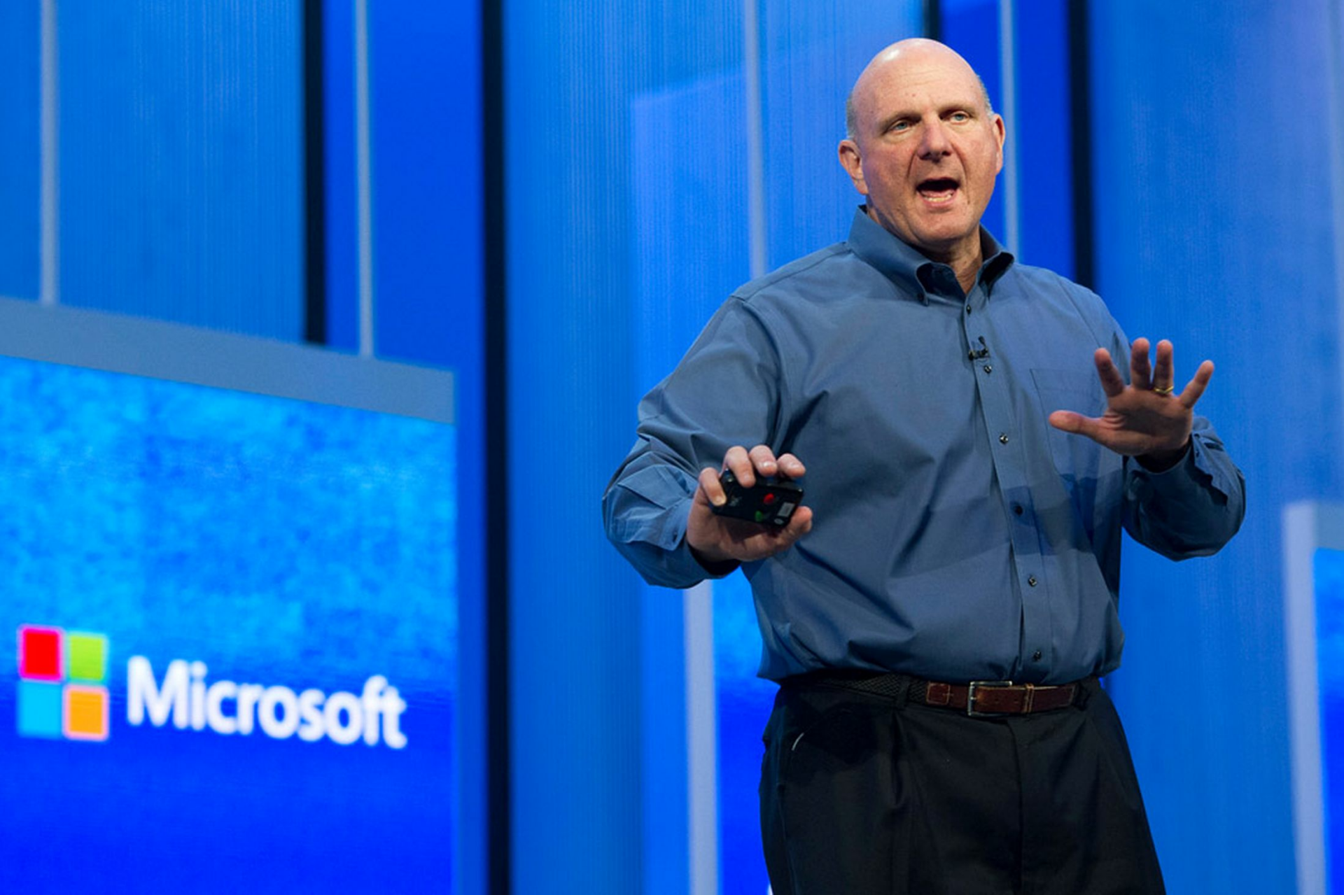 HD desktop wallpaper featuring a man giving a presentation with a Microsoft logo in the background.