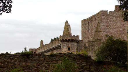 HD PC desktop wallpaper and background showing man-made Craigmillar Castle's weathered stone castle wall and battlements against an overcast sky.