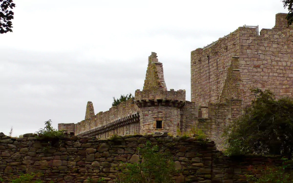 HD PC desktop wallpaper and background showing man-made Craigmillar Castle's weathered stone castle wall and battlements against an overcast sky.