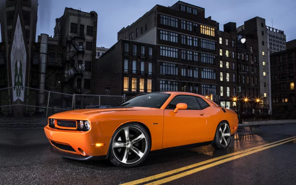 HD PC desktop wallpaper featuring an orange Dodge Challenger RT Shaker parked on a city street at dusk, highlighting the sleek design of the Dodge Challenger RT.