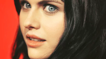 A striking HD desktop wallpaper featuring actress Alexandra Daddario, showcasing her captivating blue eyes and alluring expression against a vibrant backdrop.