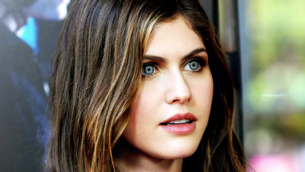 HD desktop wallpaper featuring celebrity Alexandra Daddario. She is pictured with striking blue eyes and wavy brown hair, providing a captivating and elegant background.