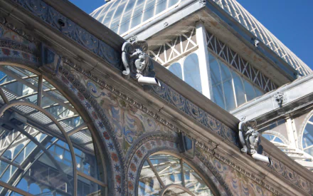 HD PC desktop wallpaper of the man-made Palacio de Cristal: ornate glass-and-iron facade and domed roof against a clear blue sky.