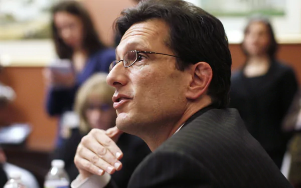 HD wallpaper of a man in a business suit attentively participating in a discussion, suitable as a desktop background.