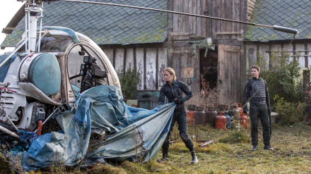 Tom Cruise and Emily Blunt in a scene from the movie Edge of Tomorrow, featuring a helicopter and a weathered backdrop, captured in stunning 4K Ultra HD quality.