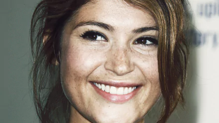 A close-up of Gemma Arterton featuring her brown eyes and freckles, radiating warmth with a bright smile. This HD image serves as a captivating desktop wallpaper.